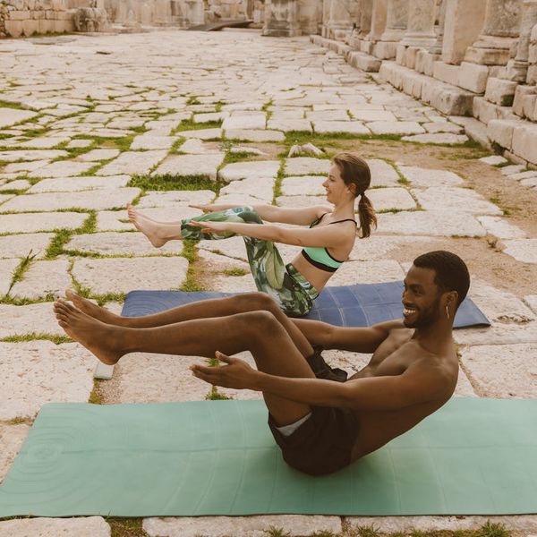 Diverse group of people smiling and sitting on yoga mats.
