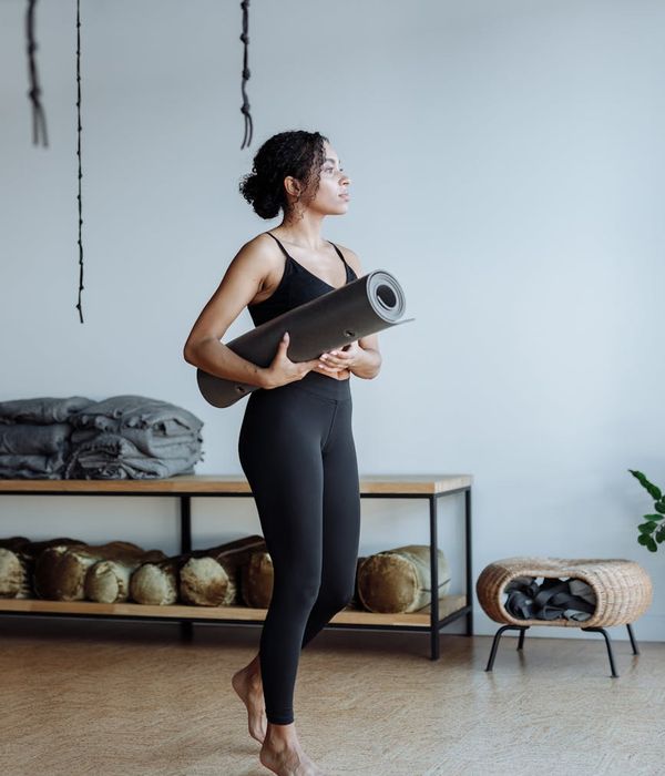 Woman maintaining a difficult balance yoga pose in a calm studio.